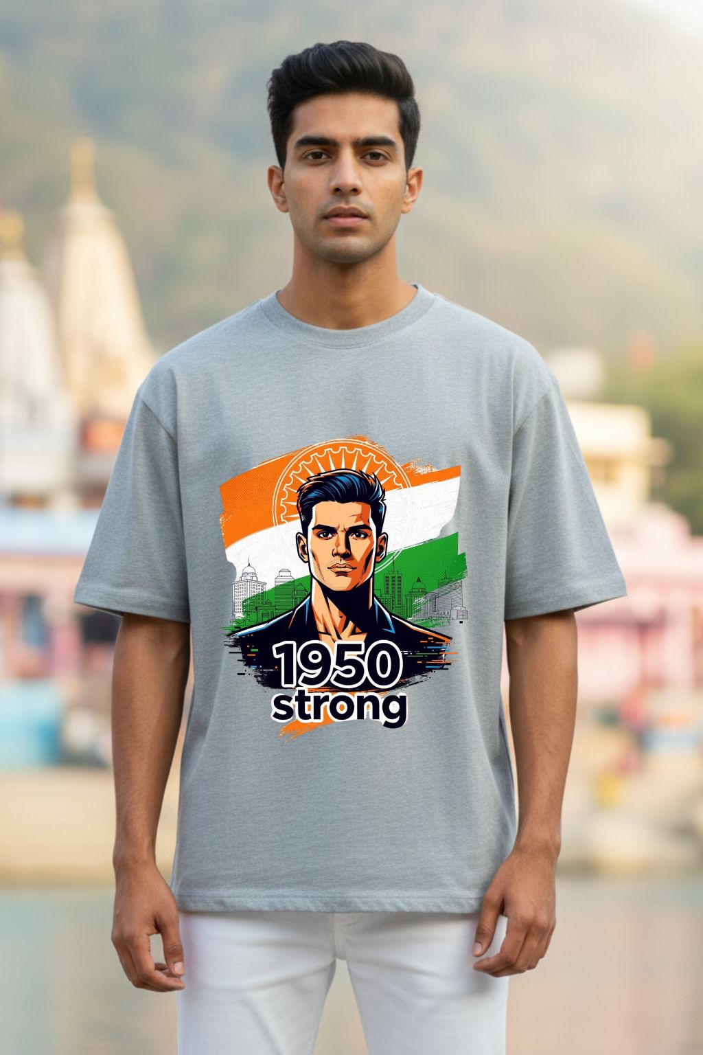 Man wearing a gray melange oversized t-shirt with a graphic design and text, standing outdoors.