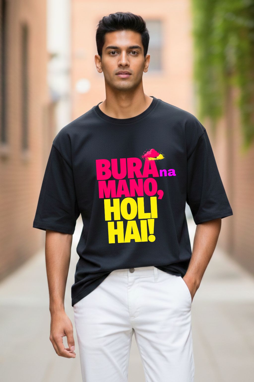 Man wearing a black oversized t-shirt with colorful text " bura na mano holi hai" in an outdoor setting
