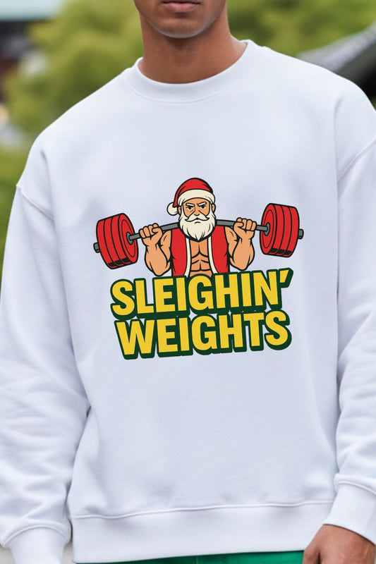 close up view of a white oversized sweatshirt with a graphic of Santa Claus lifting weights and the text 'Sleighin' Weights'.