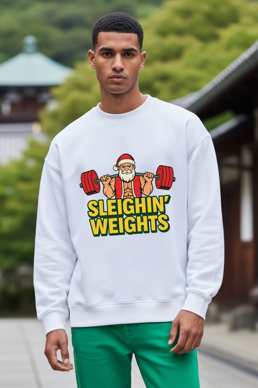Man wearing a white oversized sweatshirt with a Christmas-themed graphic and text, standing outdoors.