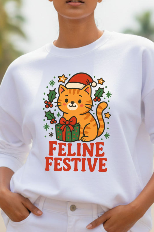 close up view of a woman wearing a white oversized sweatshirt with a festive cat design and 'Feline Festive' text.