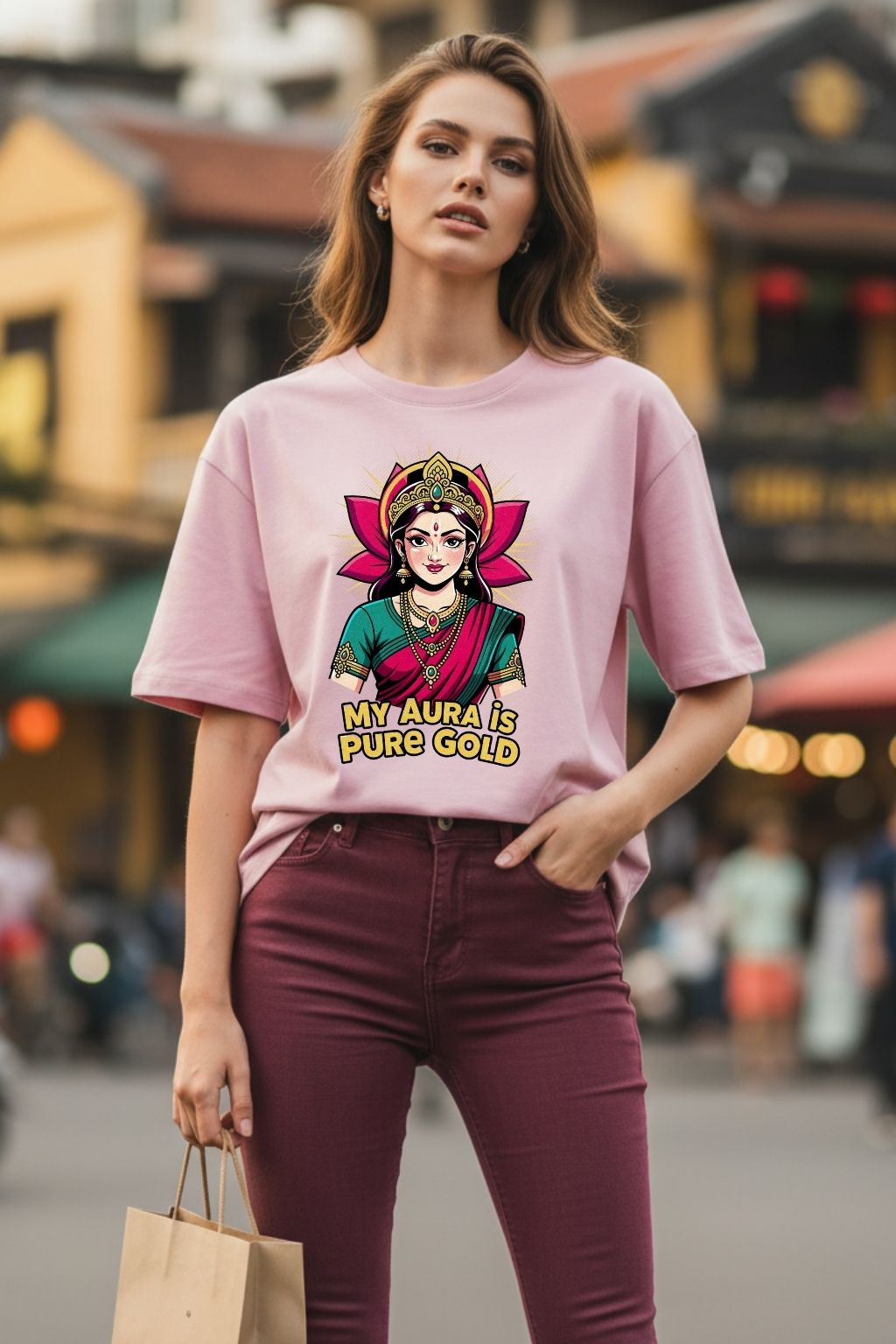woman wearing a golden aura lakshmi design on a light baby pink  oversized t-shirt