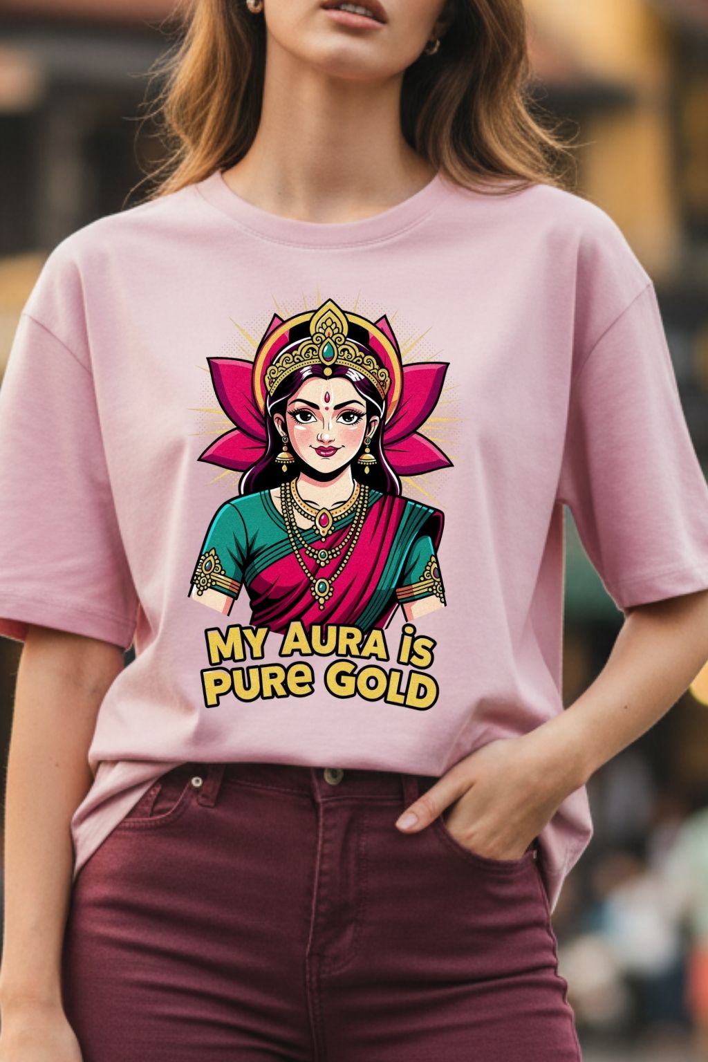 close up view of a woman wearing a golden aura lakshmi design on a light baby pink oversized t-shirt