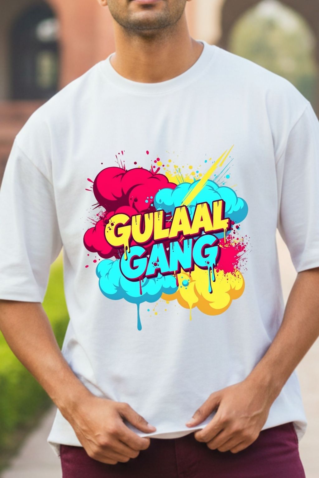 close up view of a man wearing a white oversized t-shirt with colorful 'Gulaal Gang' design.