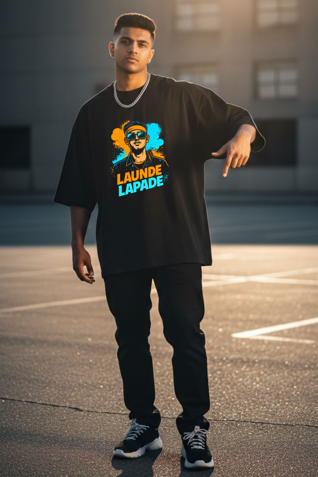 Man wearing a black oversized t-shirt with a graphic design and text "Launde Lapade", standing on an urban street.