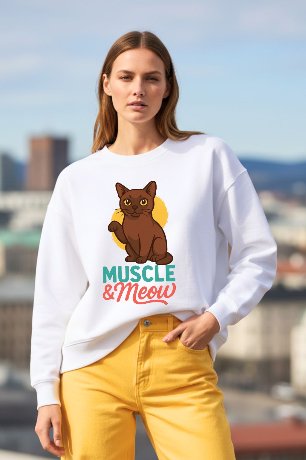 Woman wearing a white oversized sweatshirt with a cat graphic and 'Muscle & Meow' text, standing outdoors.