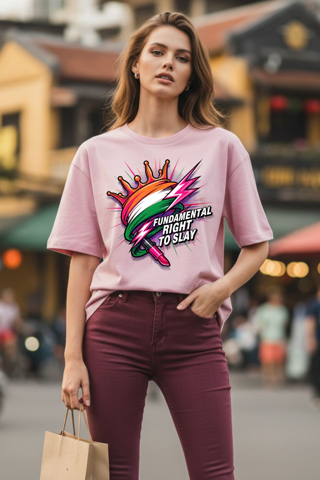 Woman wearing a light baby pink oversized  t-shirt with a colorful graphic design in an urban setting