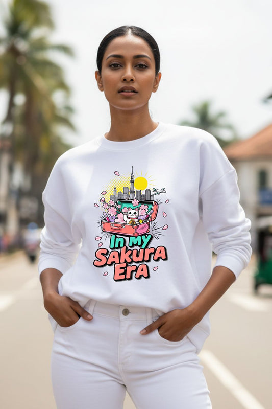 Woman wearing a white oversized sweatshirt with a colorful graphic and text, standing outdoors.