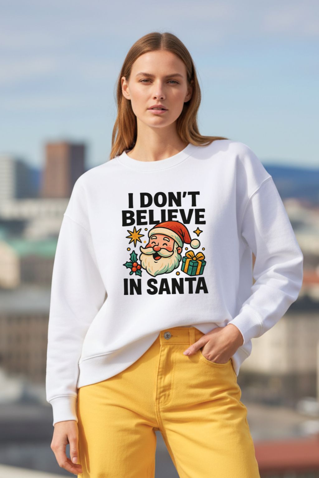 Woman wearing a white oversized sweatshirt with a Christmas-themed design and text, standing against an urban background.