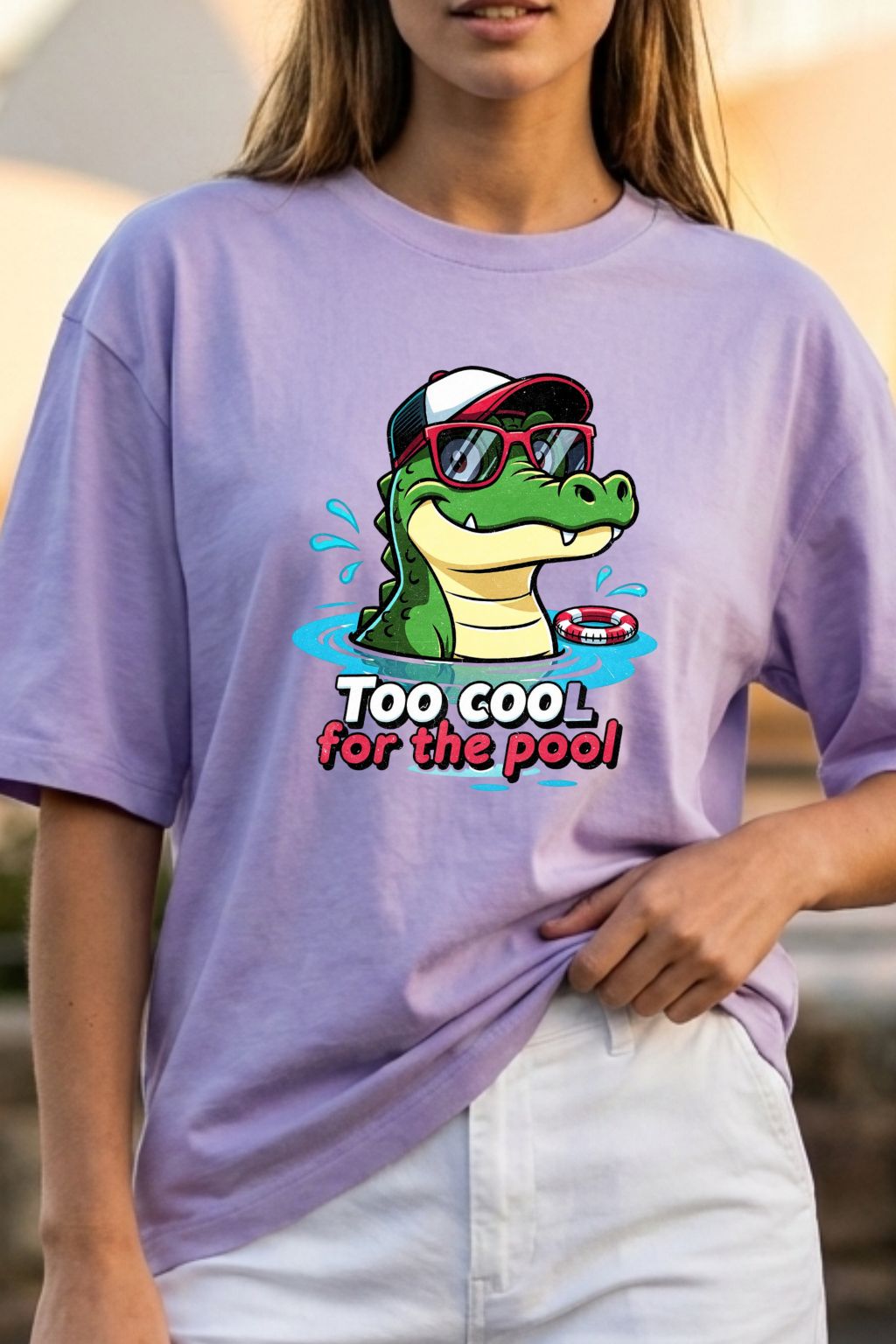 close up view of a woman wearing a lavendar oversizedt-shirt with a graphic of a crocodile and text 'Too Cool for the Pool'.