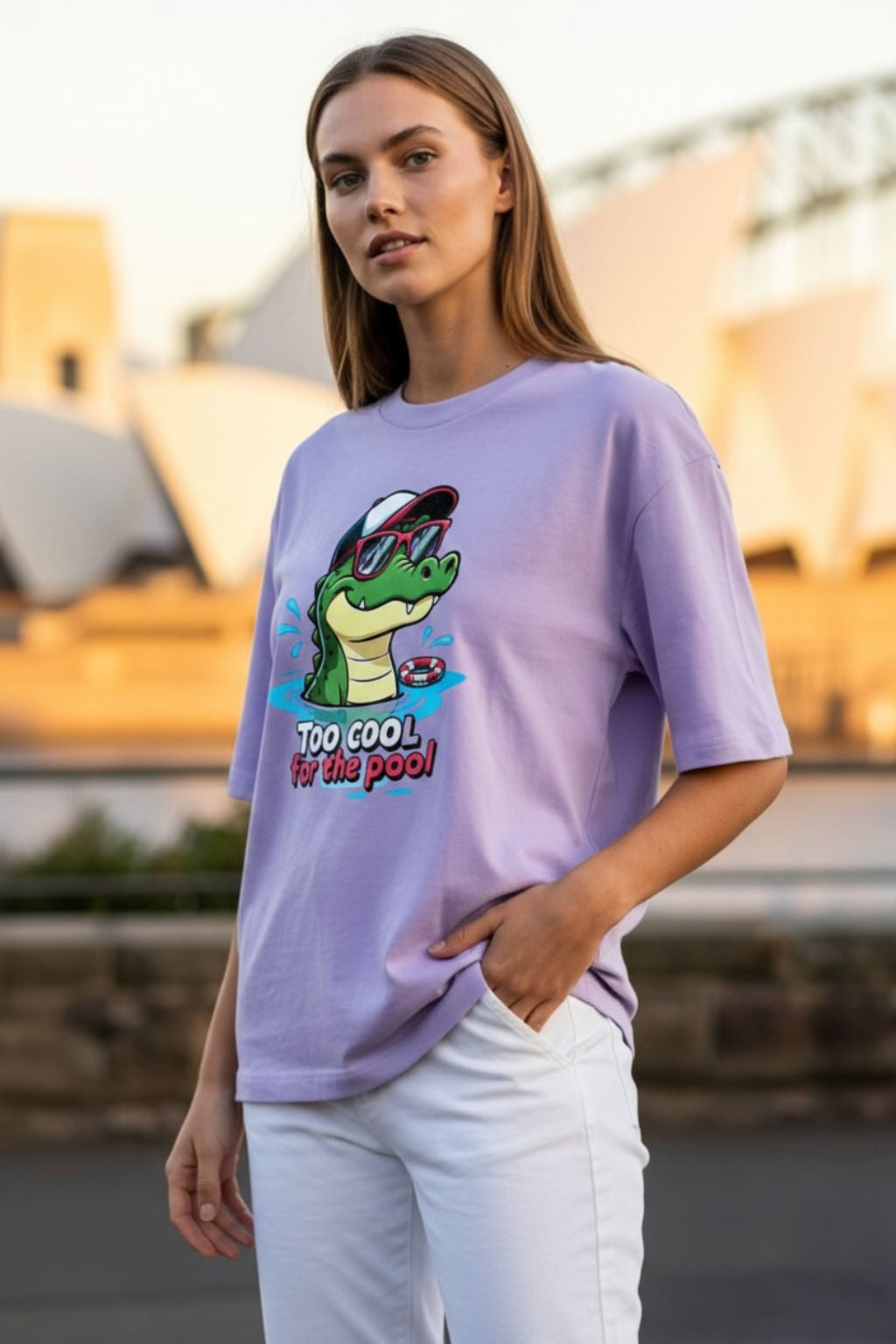 side view of a woman wearing a lavendar oversized t-shirt with a graphic design in an outdoor setting