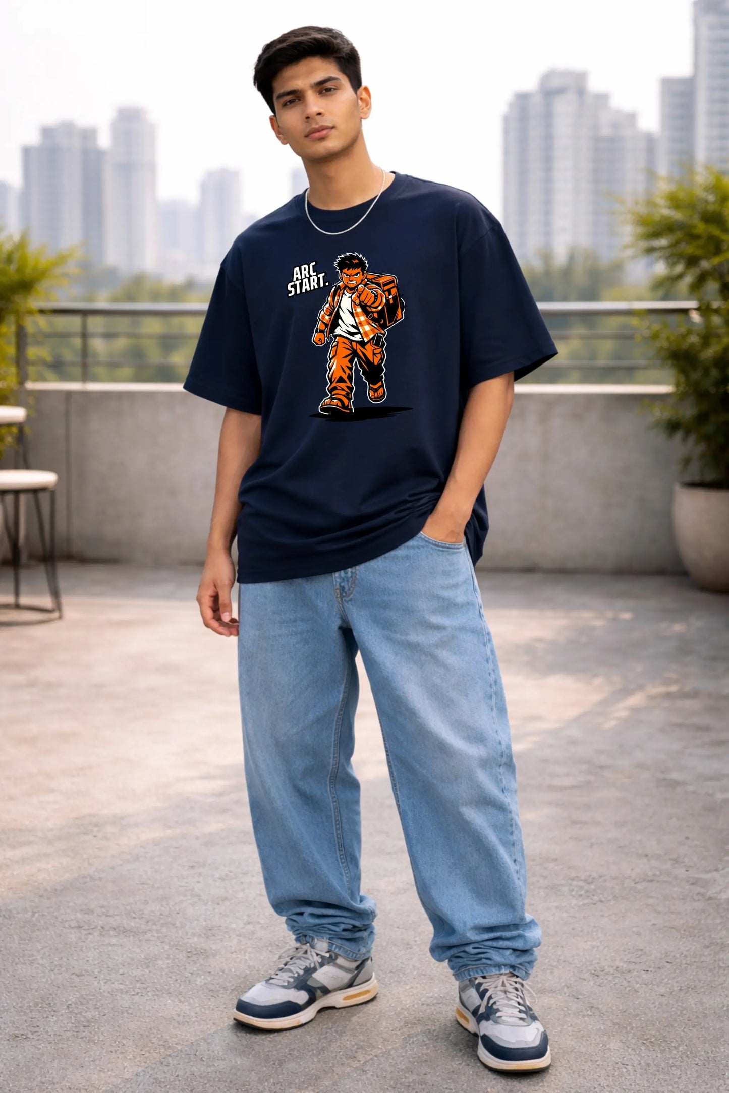 Arc Start anime oversized T-shirt in navy — Indian guy in baggy jeans and sneakers wearing desi manga streetwear on city rooftop, JUNOSHI