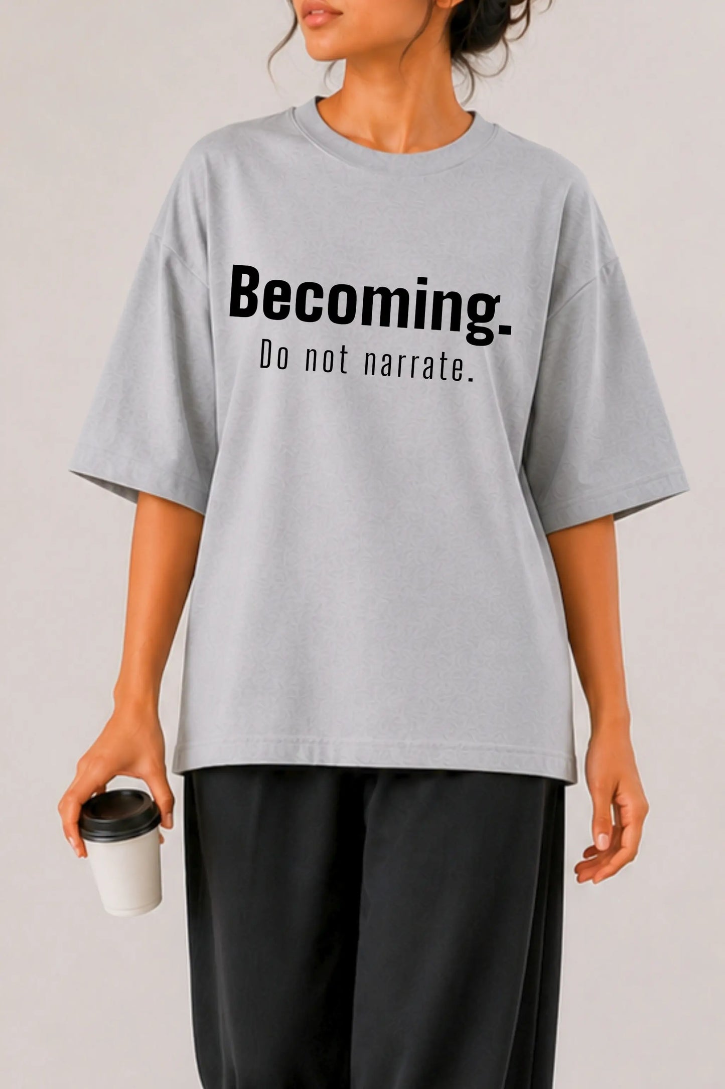 Close-up of Becoming. Do Not Narrate bold typography print on grey oversized tee — women's streetwear, DTF print detail | JUNOSHI