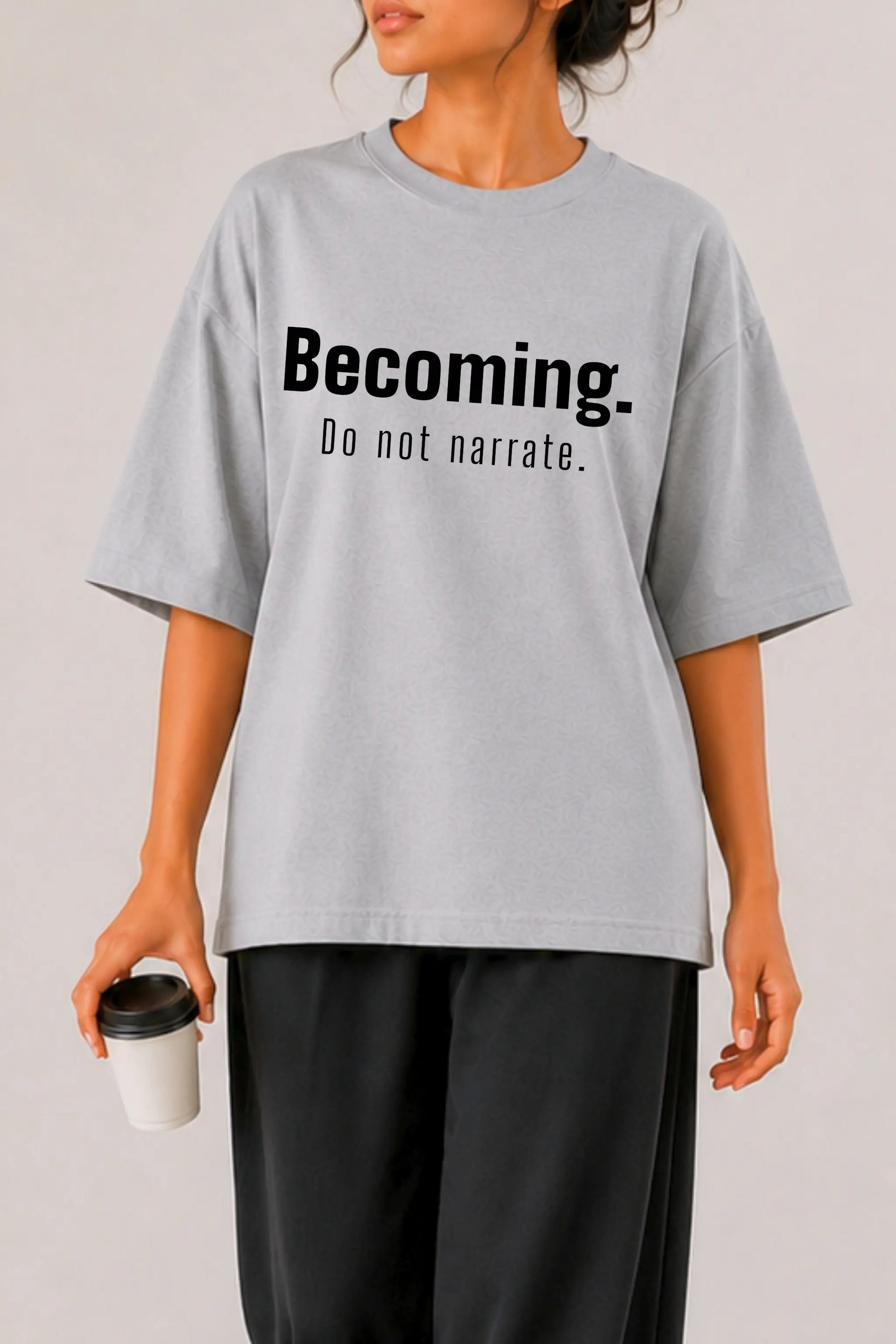 Close-up of Becoming. Do Not Narrate bold typography print on grey oversized tee — women's streetwear, DTF print detail | JUNOSHI