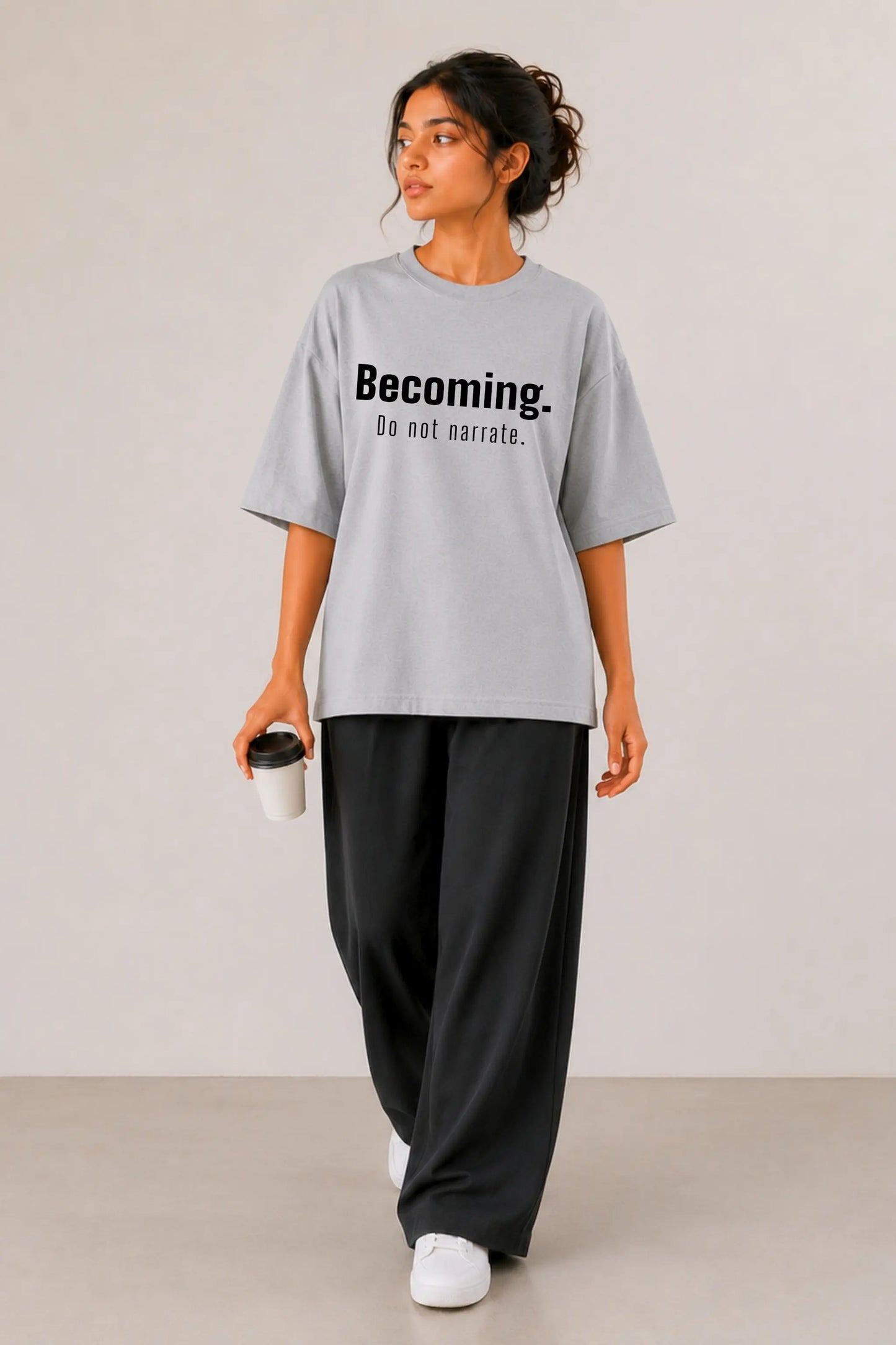 Becoming. Do Not Narrate oversized tee in grey — women's full body front view, styled with wide-leg black pants | JUNOSHI Unfiltered Collection