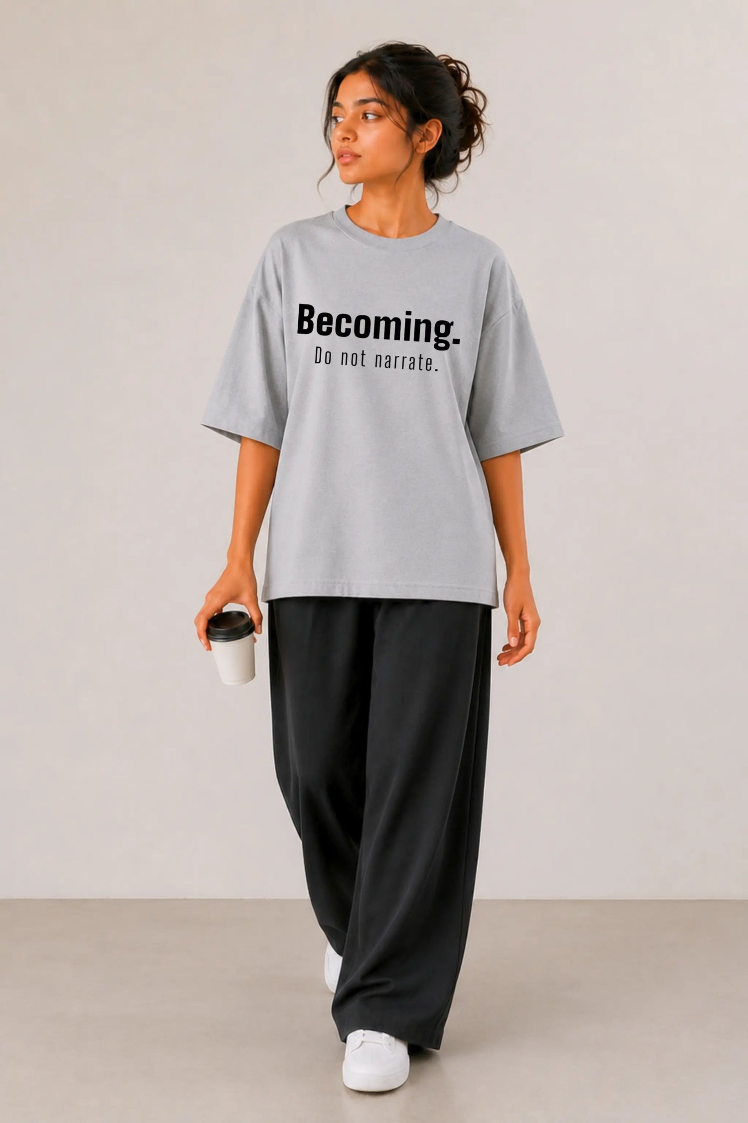 Becoming. Do Not Narrate oversized tee in grey — women's full body front view, styled with wide-leg black pants | JUNOSHI Unfiltered Collection