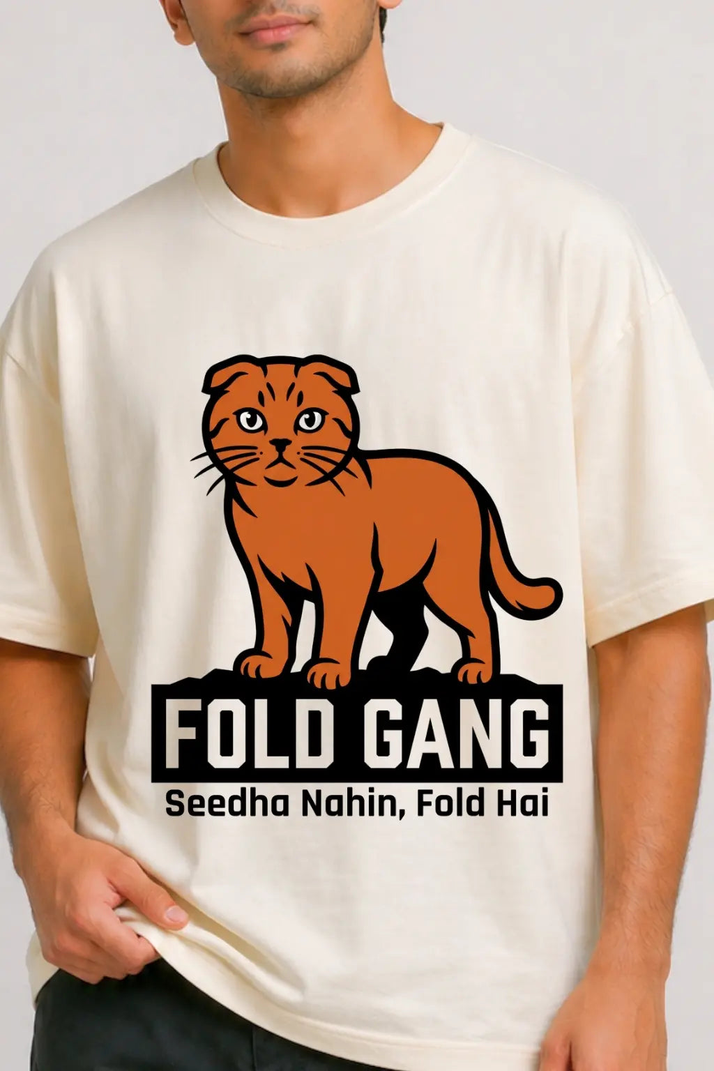 Closeup of Fold Gang graphic tee — bold Scottish Fold cat illustration with "Seedha Nahin, Fold Hai" tagline, DTF print detail on cream oversized tee | JUNOSHI