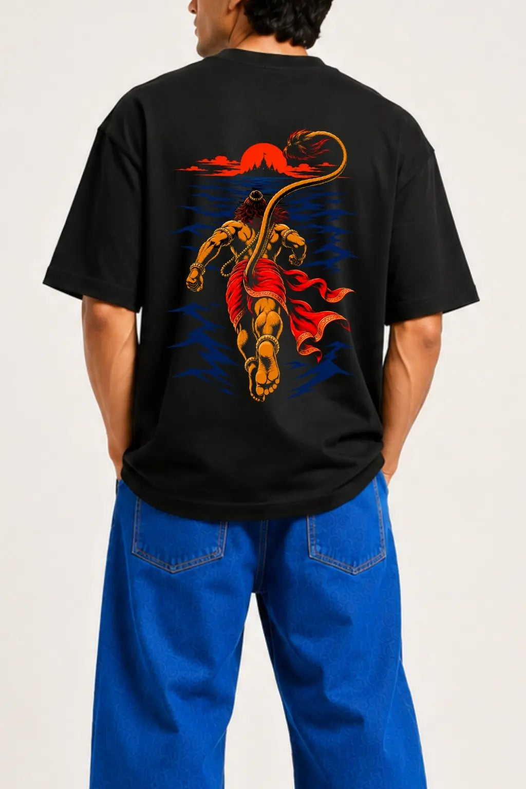 Samudra Langhan Hanuman oversized t-shirt close-up featuring back-view Hanuman leaping across the ocean toward Lanka at sunset — Divine Street devotional streetwear