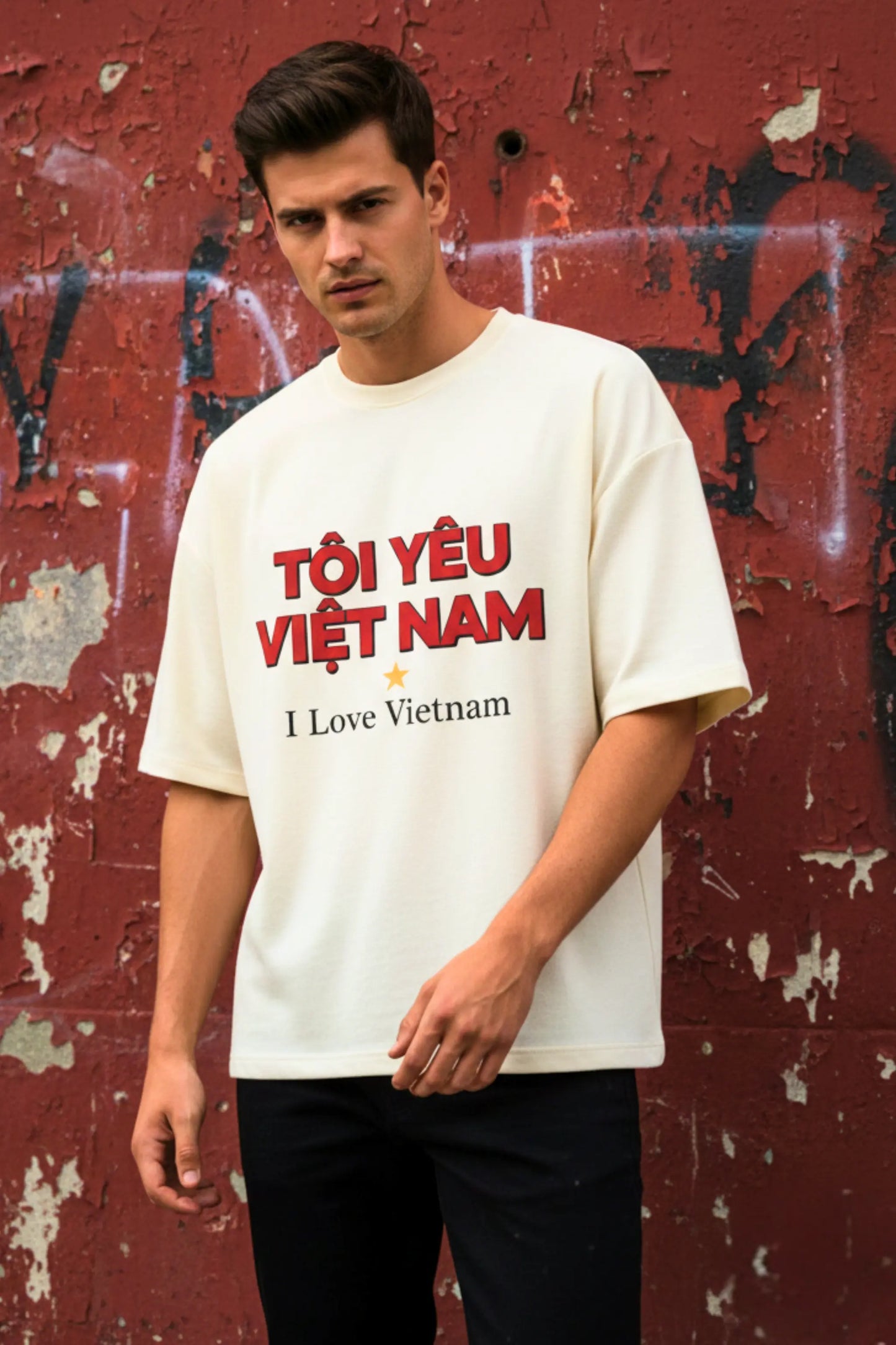 Man in off-white I Love Vietnam oversized terry t-shirt styled against a graffiti wall — streetwear travel tee for Indian wanderers | JUNOSHI