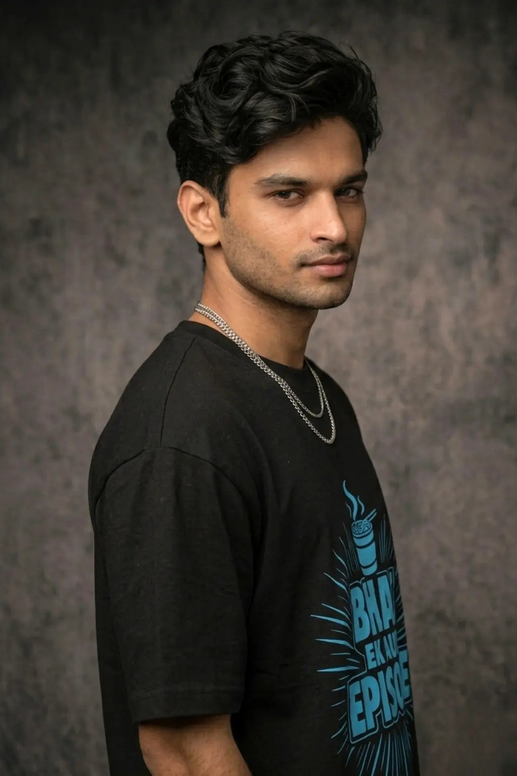 Side profile of male model wearing JUNOSHI Bhai Ek Aur Episode black oversized graphic tee