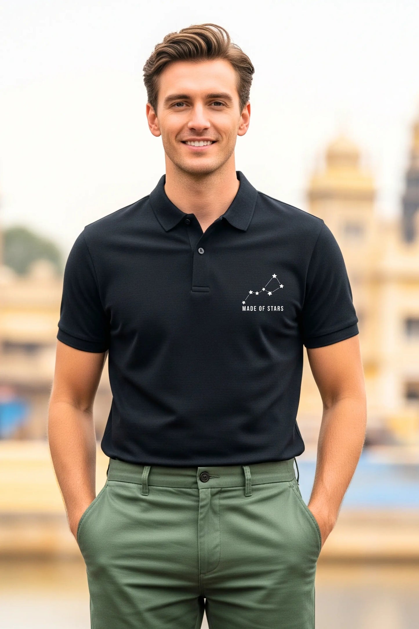 JUNOSHI Made of Stars black polo — man wearing constellation graphic polo with green chinos, Indian heritage monument in background