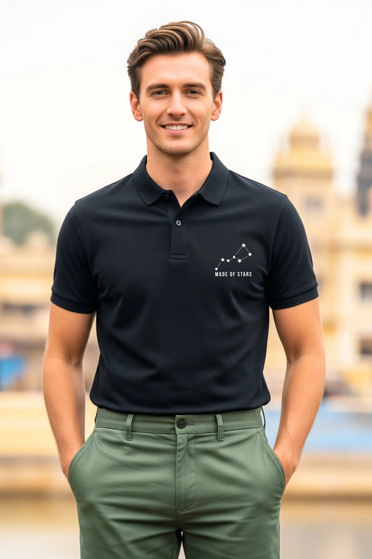 JUNOSHI Made of Stars black polo — man wearing constellation graphic polo with green chinos, Indian heritage monument in background