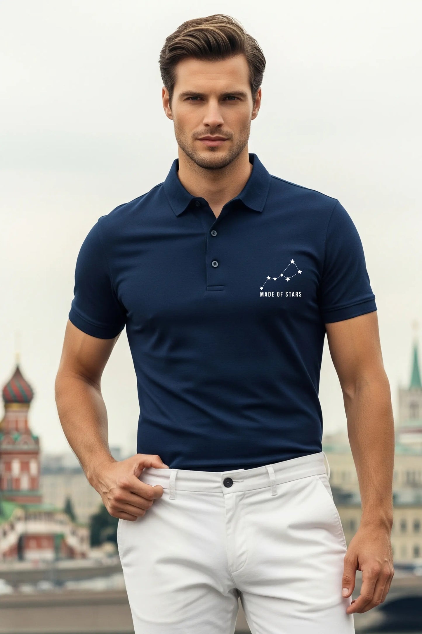 JUNOSHI Made of Stars navy polo — man wearing constellation graphic polo with white chinos, confident pose against city skyline background