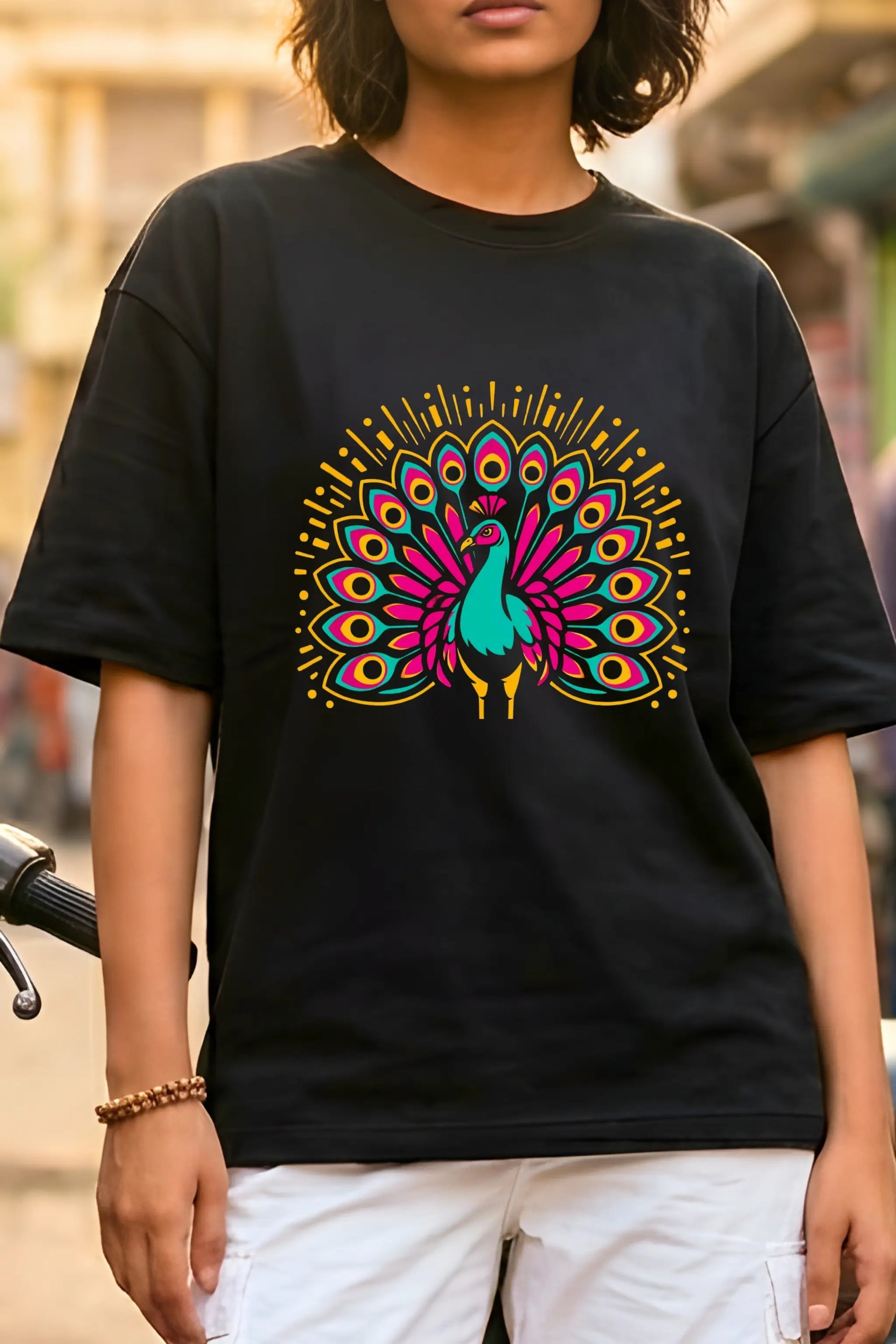 Close-up of neon peacock DTF print on black oversized terry t-shirt — vibrant teal magenta gold graphic, Junoshi