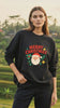 video of a young woman wearing a black oversized sweatshirt with a "santa merry christmas" design