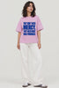 They Don’t Need Mercy — Constitutional Rights Oversized T-Shirt in lilac pink with bold blue typography, styled with white wide-leg jeans and sneakers, short video | JUNOSHI
