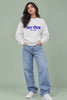 Reel of a woman in a white Aat Gondhal Baher Shantata Marathi quote oversized sweatshirt and wide-leg jeans, showing the आत गोंधळ बाहेर शांतता chest print in motion | JUNOSHI