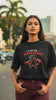 video mockup of a woman wearing a black oversized t-shirt with the design "I Am The Super Power" in an urban setting