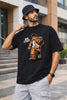 Man wearing JUNOSHI Arc Start black anime oversized terry t-shirt featuring a bold manga-style desi protagonist graphic, styled with grey cargo pants, bucket hat, and backpack