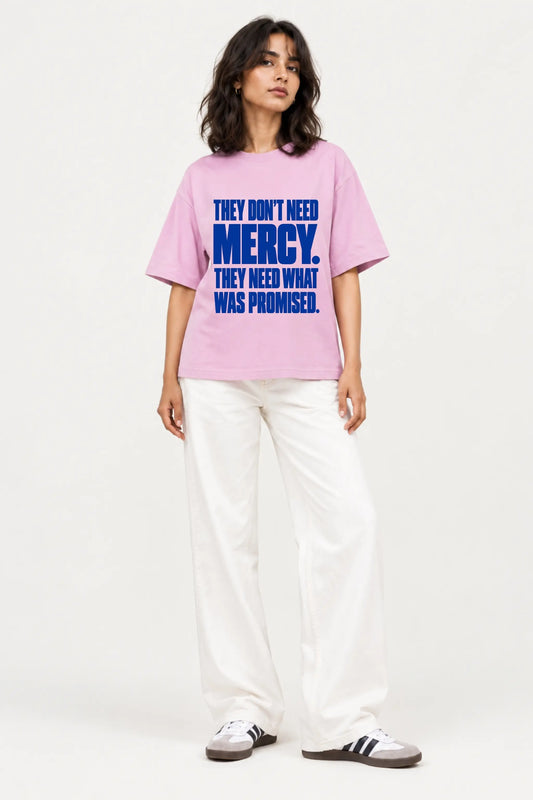 They Don’t Need Mercy — Constitutional Rights Oversized T-Shirt in lilac pink, worn by woman with white wide-leg jeans, front view | JUNOSHI